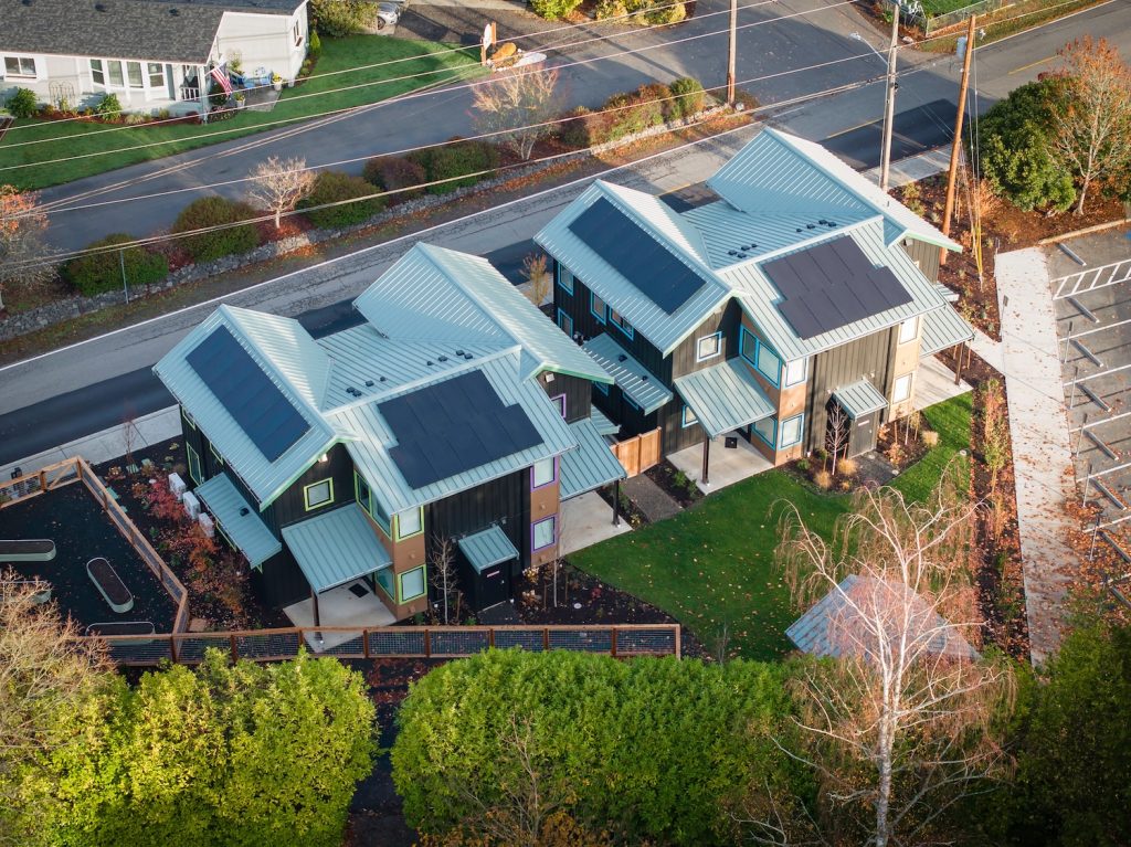 Aerial drone image of Poulsbo's first city-backed affordable housing community, the Nordic Cottages. A solar array is visible across the two buildings that make up the community